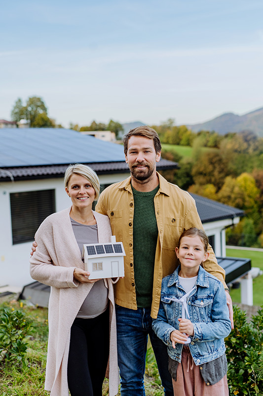 Familie vor ihrem Haus mit einer Solaranlage von energiehaus blechinger aus Wolfsburg